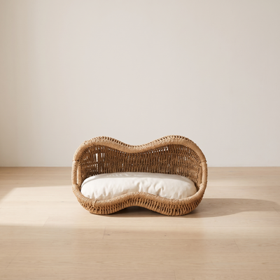 Arachide rattan cat bed in a minimal room with pale oak floor