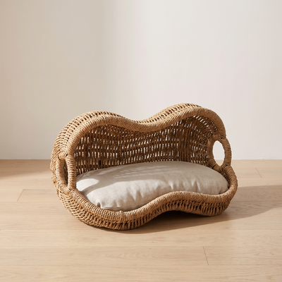 Arachide rattan cat bed three quarter view showing the cane weave and cushion