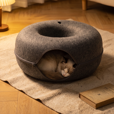 Donut felt cat nest in a warm evening interior with a cat asleep inside