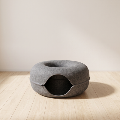 Donut felt cat nest in a minimal room with pale oak floor