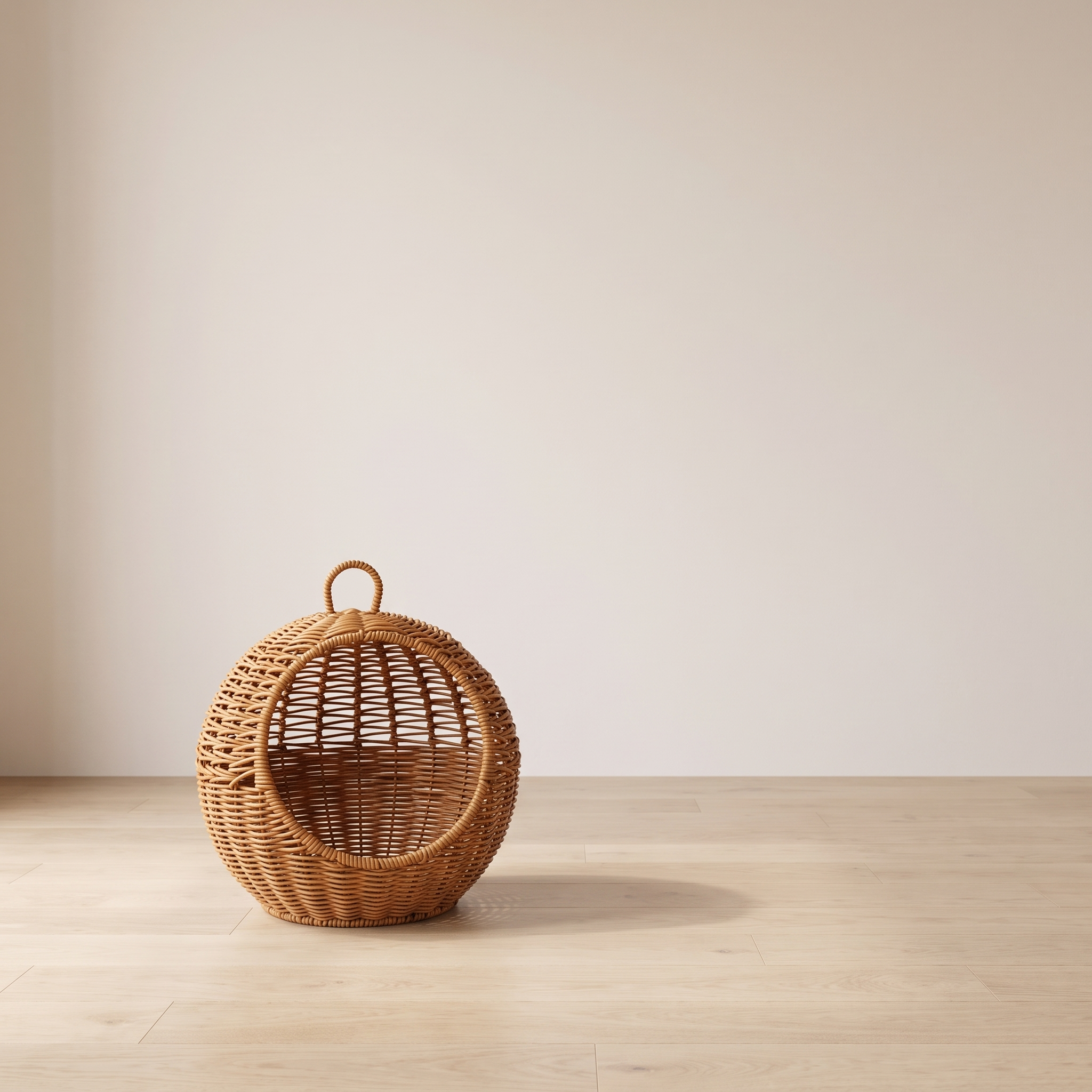 Perla hanging rattan cat basket bed in a minimal room against a warm off-white wall