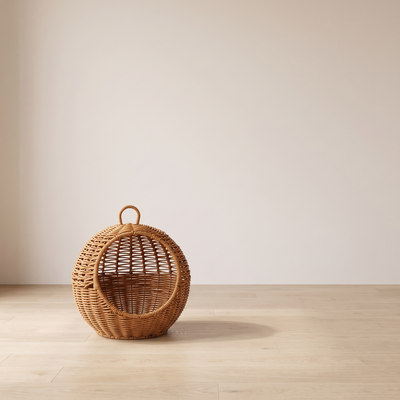 Perla hanging rattan cat basket bed in a minimal room against a warm off-white wall